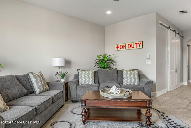 living room featuring a barn door and light tile patterned flooring