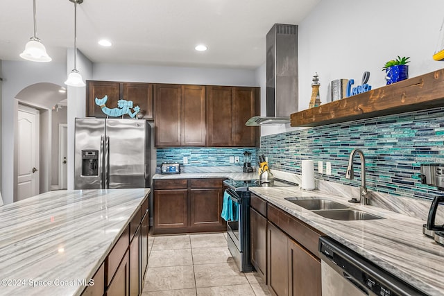 kitchen featuring stainless steel appliances, light stone counters, wall chimney exhaust hood, and sink