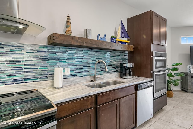 kitchen featuring sink, stainless steel appliances, backsplash, dark brown cabinets, and light tile patterned flooring