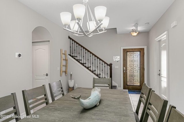 tiled dining room featuring an inviting chandelier