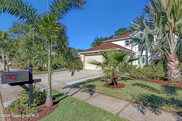 view of front of house featuring a garage and a front lawn