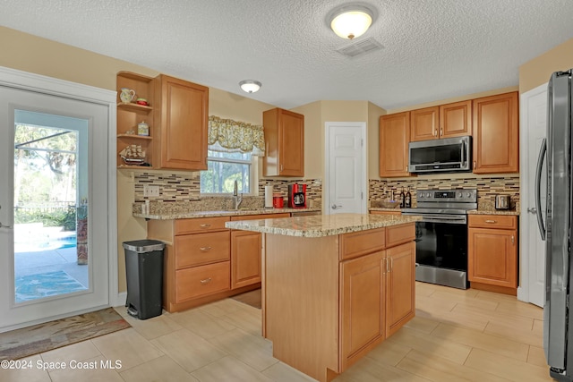 kitchen with decorative backsplash, appliances with stainless steel finishes, a center island, and a healthy amount of sunlight