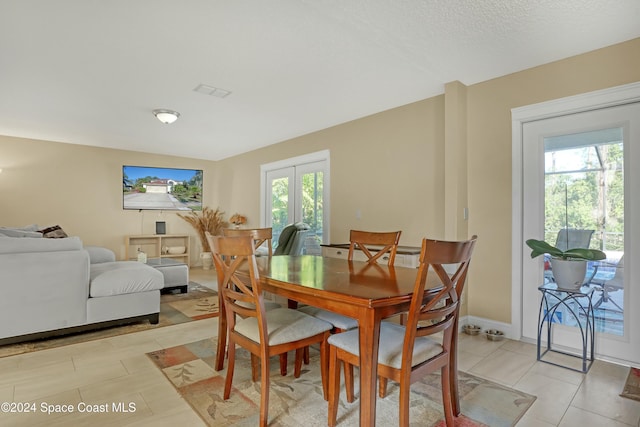 dining area with french doors, light tile patterned floors, and a wealth of natural light