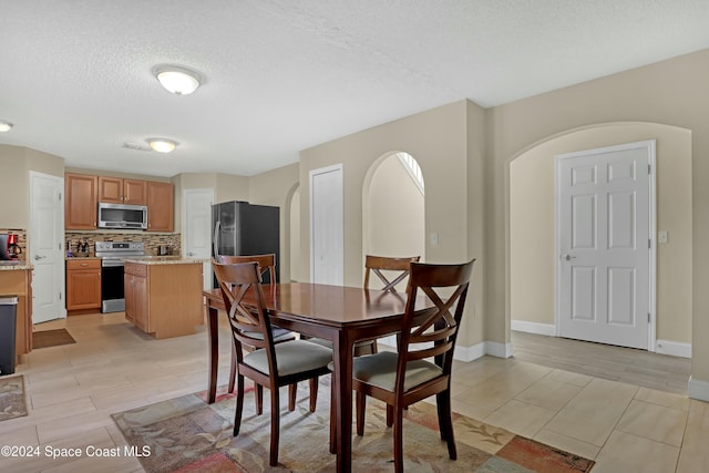 dining room featuring a textured ceiling and light hardwood / wood-style flooring