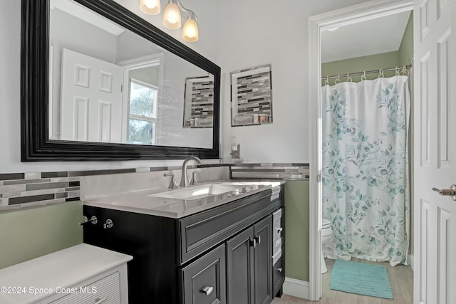 bathroom with decorative backsplash, a shower with curtain, vanity, hardwood / wood-style floors, and toilet