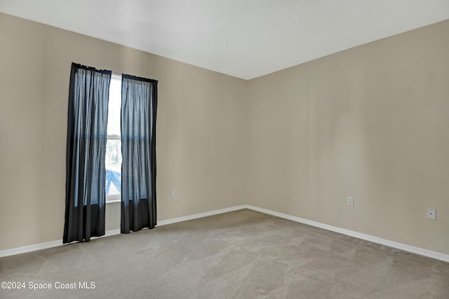 unfurnished room featuring light carpet