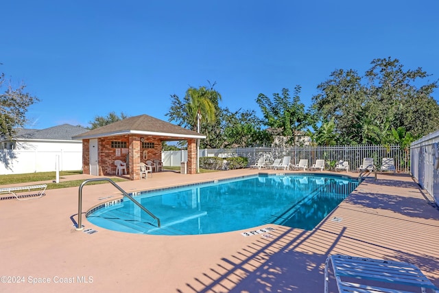 view of swimming pool featuring an outbuilding and a patio