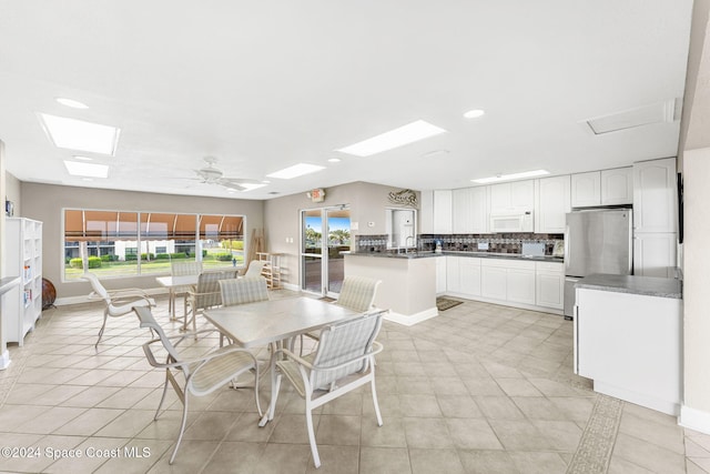 tiled dining area with plenty of natural light and ceiling fan