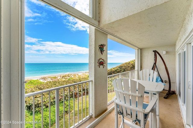 balcony featuring a water view and a view of the beach