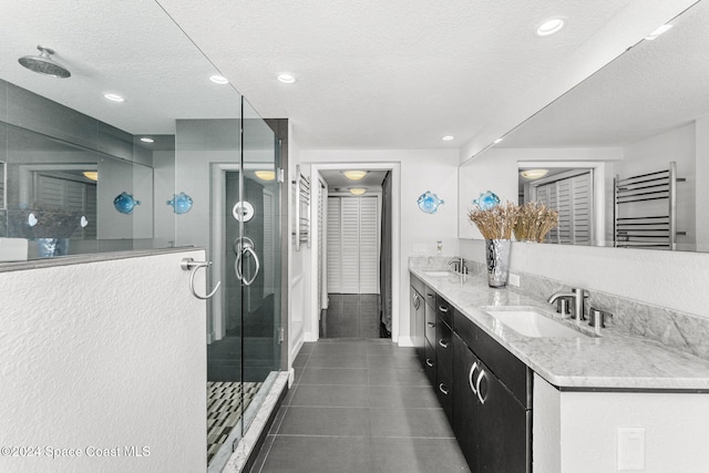 bathroom featuring vanity, radiator, tile patterned floors, a textured ceiling, and an enclosed shower