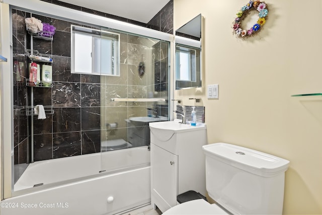 full bathroom featuring enclosed tub / shower combo, vanity, a healthy amount of sunlight, and toilet