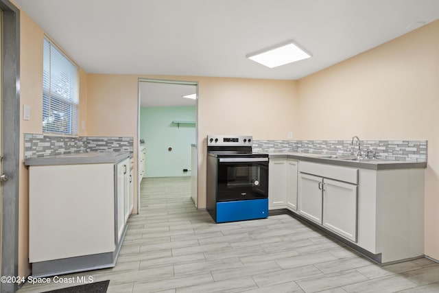 kitchen featuring white cabinets, sink, decorative backsplash, range with electric stovetop, and light hardwood / wood-style floors