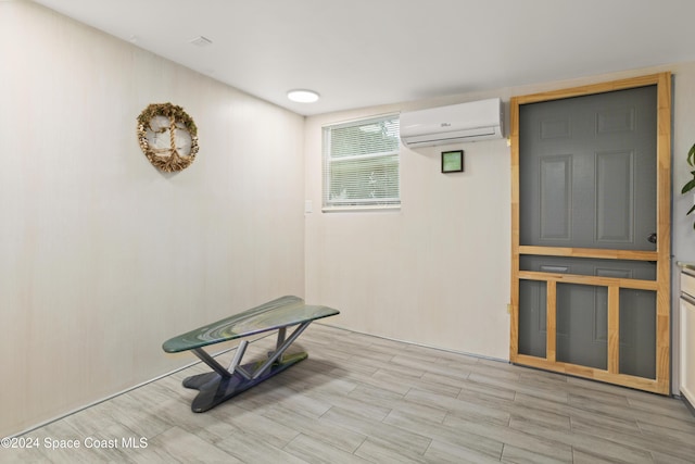 miscellaneous room with light wood-type flooring and an AC wall unit