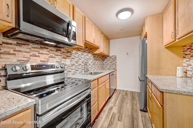 kitchen with backsplash, light brown cabinetry, sink, and stainless steel appliances