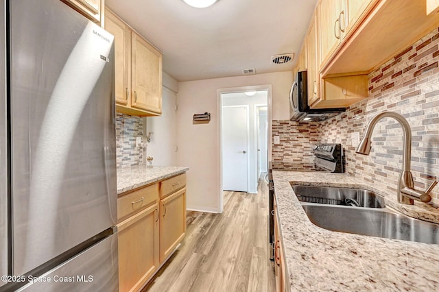 kitchen featuring tasteful backsplash, stainless steel fridge, sink, and light brown cabinets