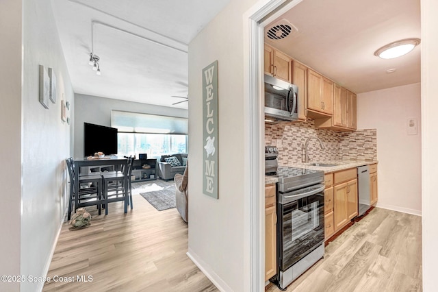 kitchen with light brown cabinets, sink, appliances with stainless steel finishes, and tasteful backsplash