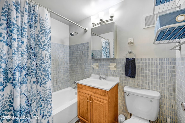 bathroom with vanity, toilet, and tile walls