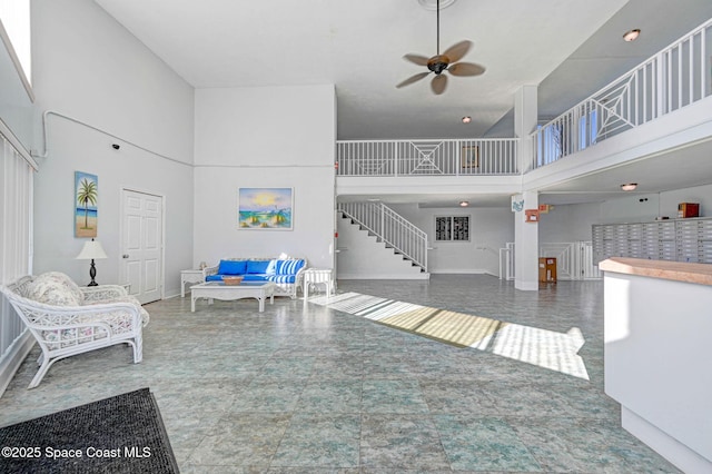 living room with ceiling fan and a high ceiling