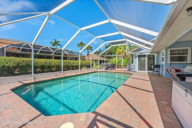 view of pool featuring glass enclosure and a patio area