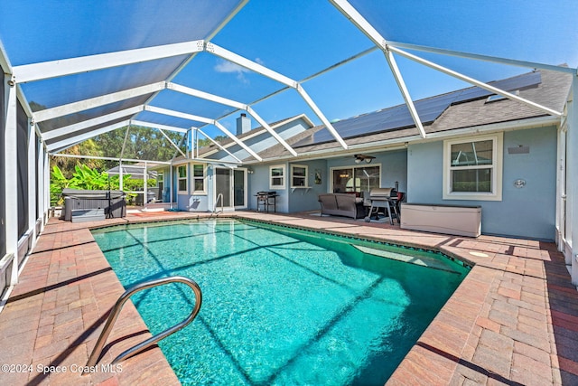 view of swimming pool featuring a hot tub, a lanai, and a patio area