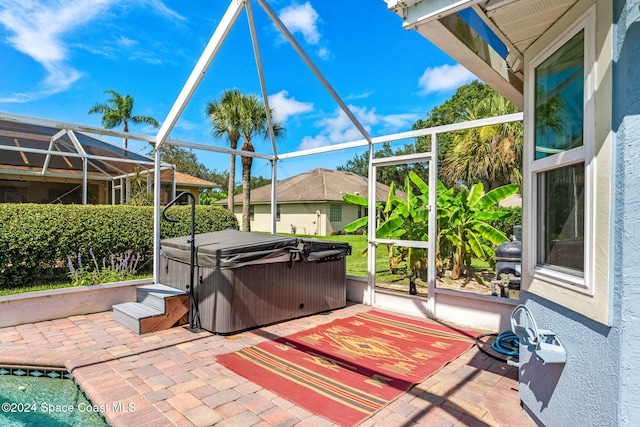 view of patio / terrace with glass enclosure and a hot tub