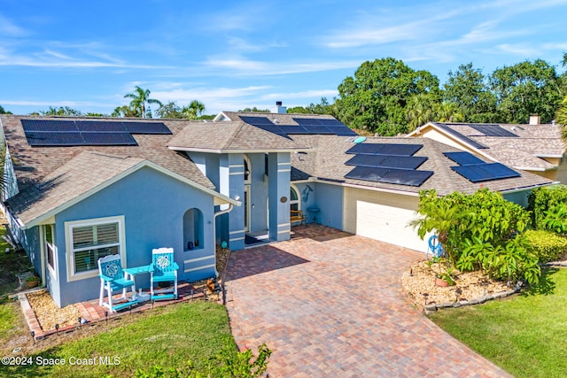 view of front facade with solar panels and a garage