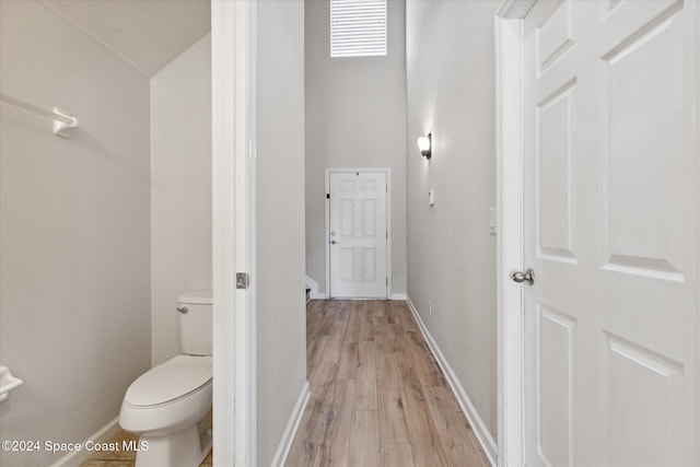 bathroom featuring vaulted ceiling, hardwood / wood-style flooring, and toilet