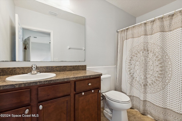 bathroom with vanity, a textured ceiling, and toilet