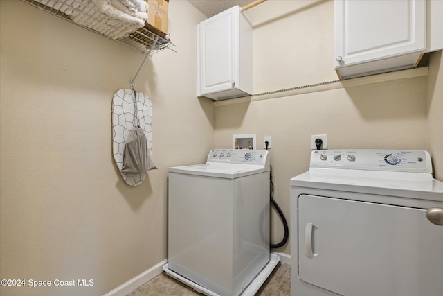 laundry area featuring separate washer and dryer and cabinets