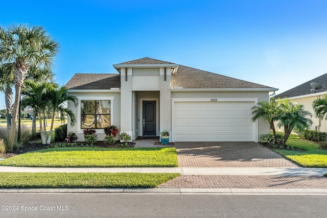 view of front of house with a front lawn, decorative driveway, a garage, and stucco siding