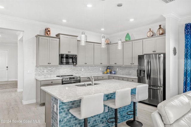 kitchen featuring gray cabinets, a sink, decorative backsplash, appliances with stainless steel finishes, and crown molding