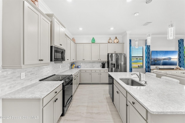 kitchen featuring black appliances, ornamental molding, and a sink