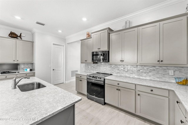 kitchen with visible vents, gray cabinets, appliances with stainless steel finishes, and a sink