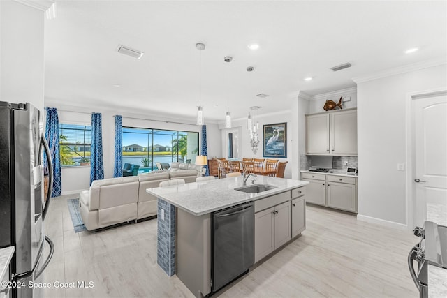 kitchen featuring gray cabinetry, ornamental molding, a sink, stainless steel appliances, and light stone countertops