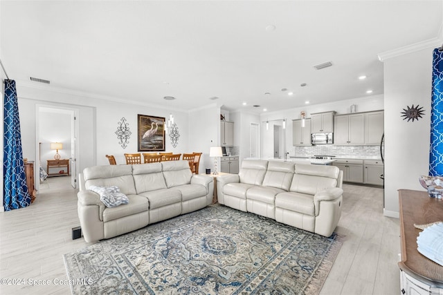 living area featuring recessed lighting, visible vents, light wood-style flooring, and crown molding