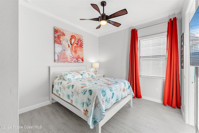 bedroom with light wood-style floors, baseboards, and ornamental molding