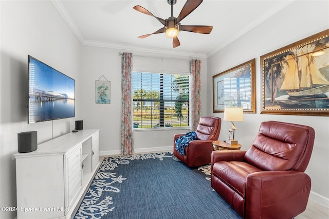 living area with ceiling fan, baseboards, and ornamental molding