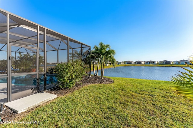 view of yard with a lanai, an outdoor pool, and a water view