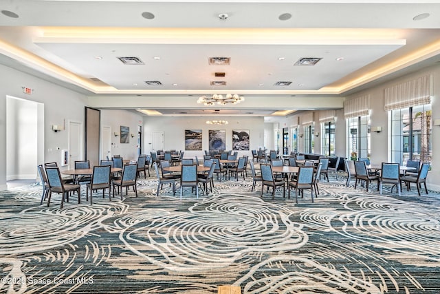 dining room with a tray ceiling and visible vents