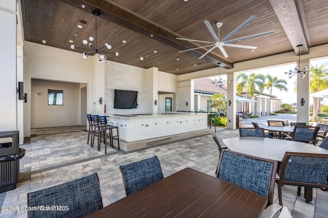 view of patio / terrace featuring outdoor wet bar, outdoor dining area, and a ceiling fan