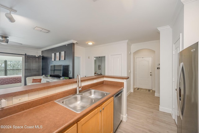 kitchen featuring appliances with stainless steel finishes, light hardwood / wood-style floors, ornamental molding, and sink