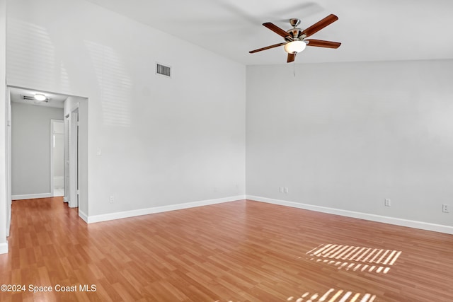 empty room with ceiling fan and light hardwood / wood-style flooring