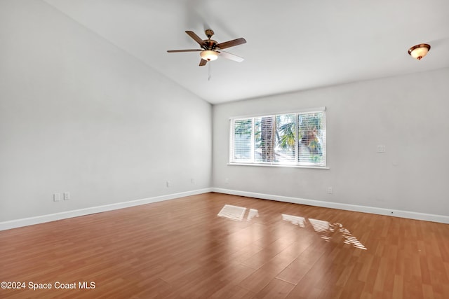 empty room with ceiling fan, hardwood / wood-style floors, and vaulted ceiling