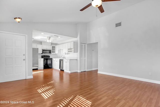 unfurnished living room featuring ceiling fan, light wood-type flooring, and vaulted ceiling