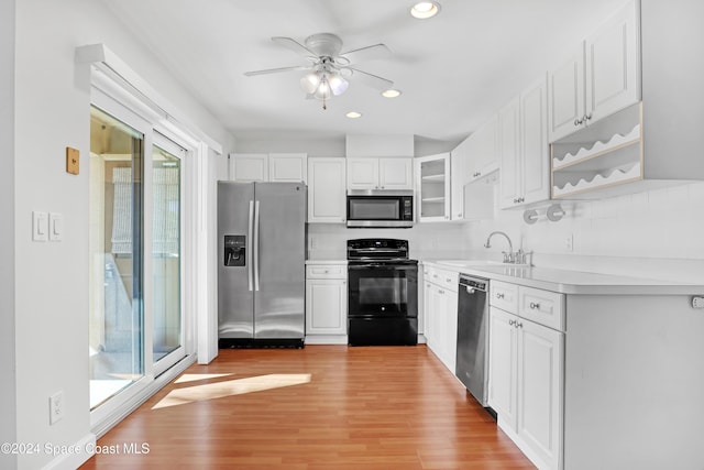 kitchen featuring appliances with stainless steel finishes, ceiling fan, sink, light hardwood / wood-style floors, and white cabinetry