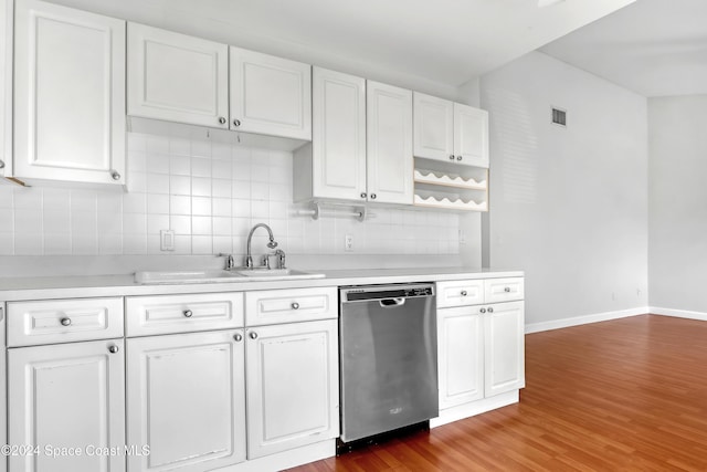 kitchen featuring tasteful backsplash, sink, hardwood / wood-style flooring, dishwasher, and white cabinetry