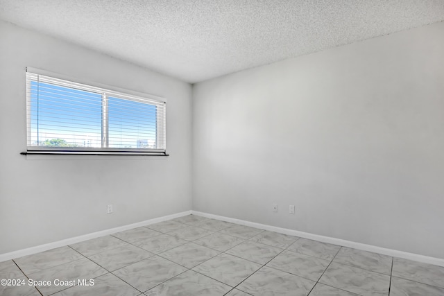 spare room with a textured ceiling