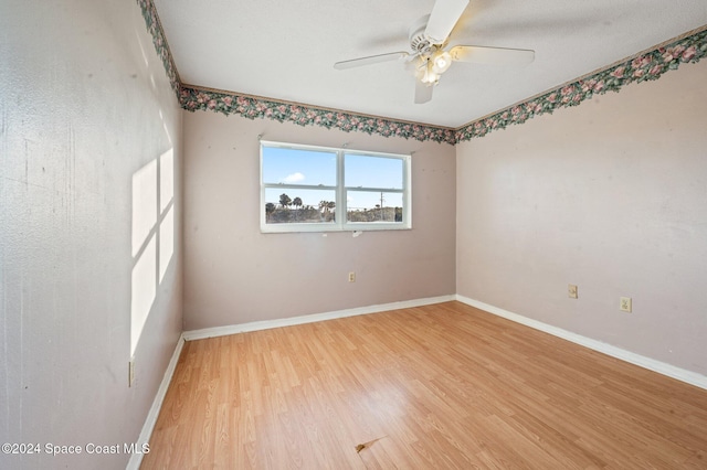 spare room with hardwood / wood-style flooring and ceiling fan