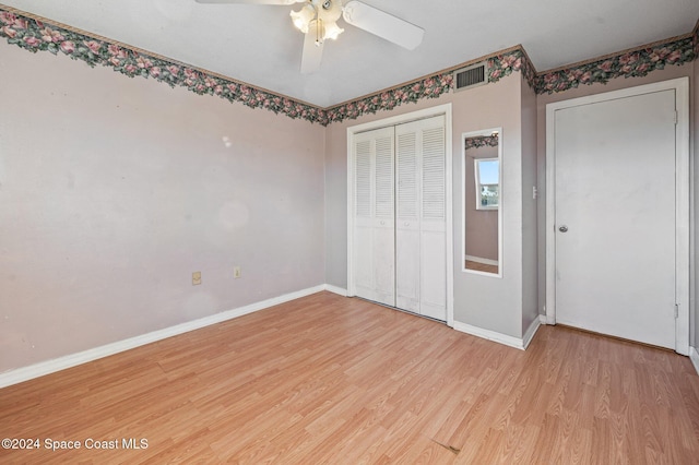 unfurnished bedroom with a closet, light hardwood / wood-style floors, and ceiling fan