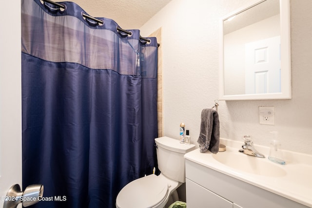 bathroom with vanity, toilet, a textured ceiling, and walk in shower